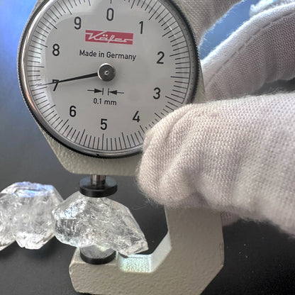 A dial gauge measures the Herkimer rough cut gemstone