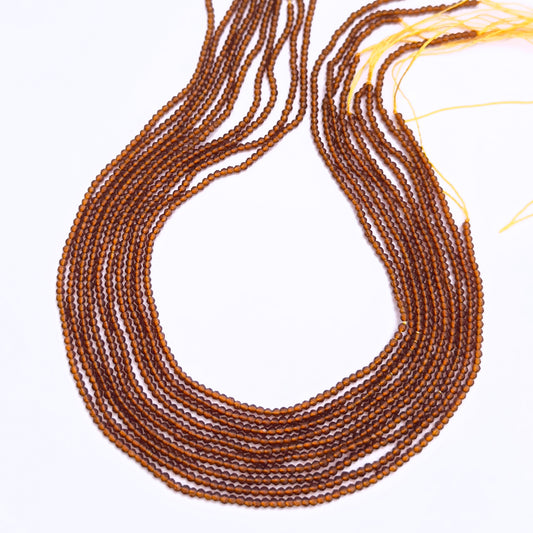 Natural Hessonite stone beads arranged in strands with golden-brown shimmer.