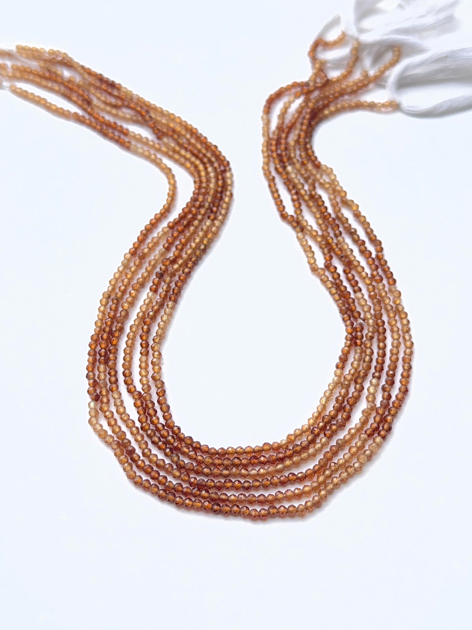 Hessonite gemstone beads arranged to showcase their rich colour and precision faceting for DIY jewellery.