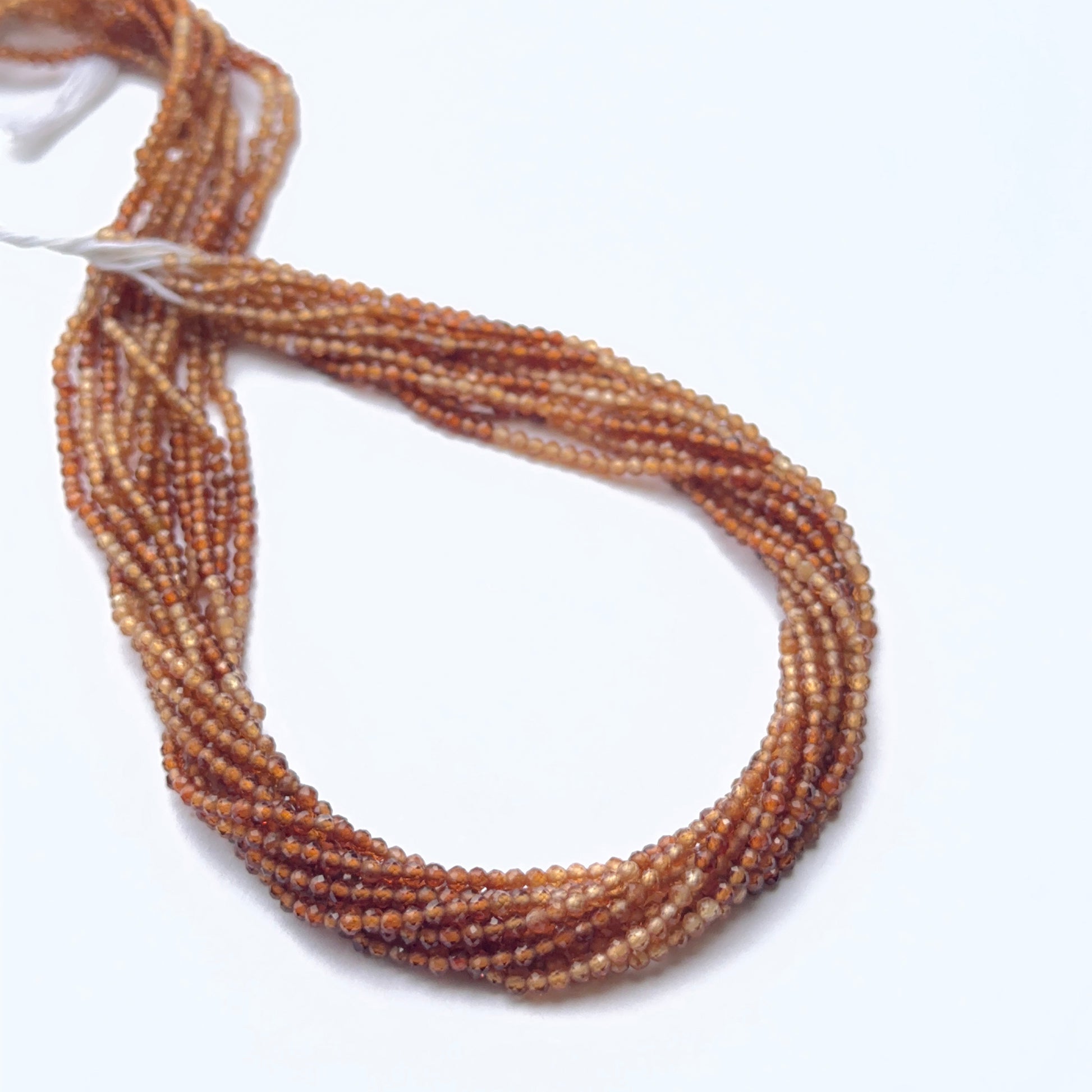 Faceted hessonite rondelles displayed with bright reflective surfaces ideal for handmade jewellery components.