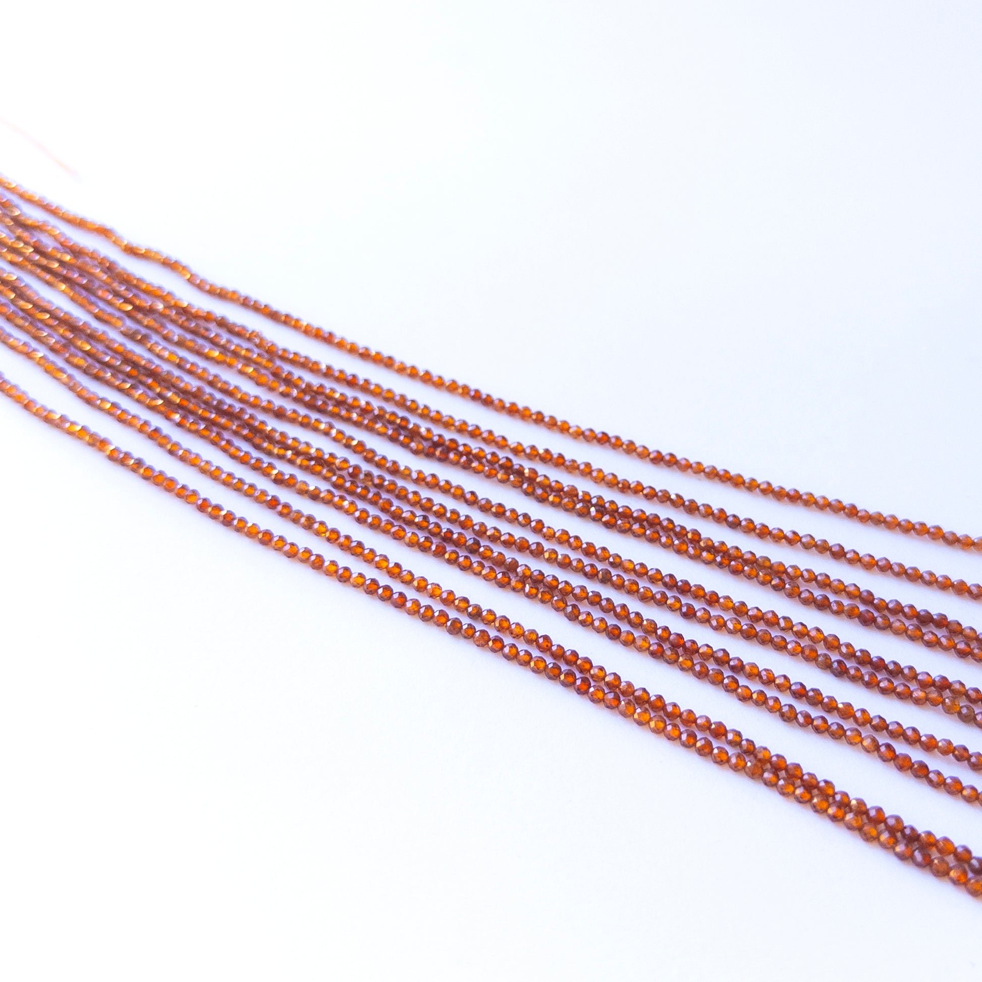 Handmade jewellery components featuring natural Hessonite faceted rondelles, highlighting their colour, clarity, and bright shine.