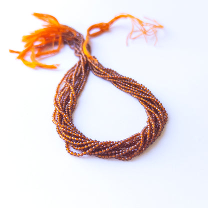 Genuine Hessonite gemstone beads displaying warm honey‑brown tones, polished facets, and a neatly arranged 32cm strand for jewellery design.