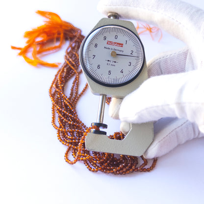 A dial gauge measures the Hessonite faceted rondelle 2.4mm gemstone.