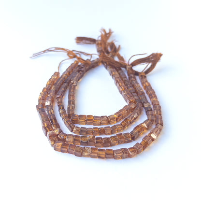 Hessonite smooth cube gemstone beads in warm honey‑brown tones arranged on a 20cm strand for handmade jewellery components.
