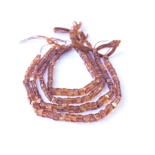 Hessonite smooth cube gemstone beads in warm honey‑brown tones arranged on a 20cm strand for handmade jewellery components.