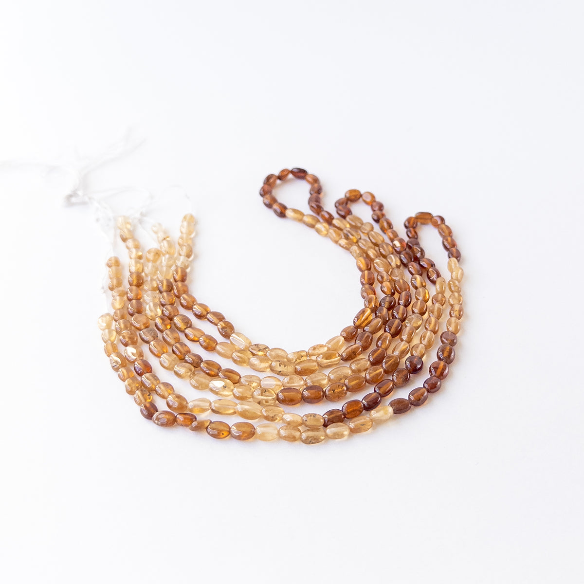 Hessonite smooth oval beads 4–4.5mm showing warm honey‑brown tones and natural glow on a 40cm strand.