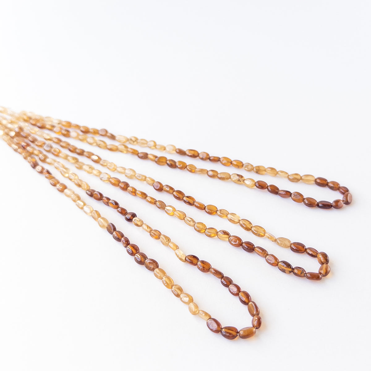 High‑quality smooth oval Hessonite beads with polished shine and uniform arrangement ideal for handcrafted jewellery.