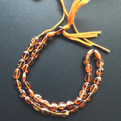 Detailed view of 33cm strand of Hessonite beads with glossy surface and uniform shape. Stone beads with polished finish and warm glow, perfect for elegant handmade jewellery. 