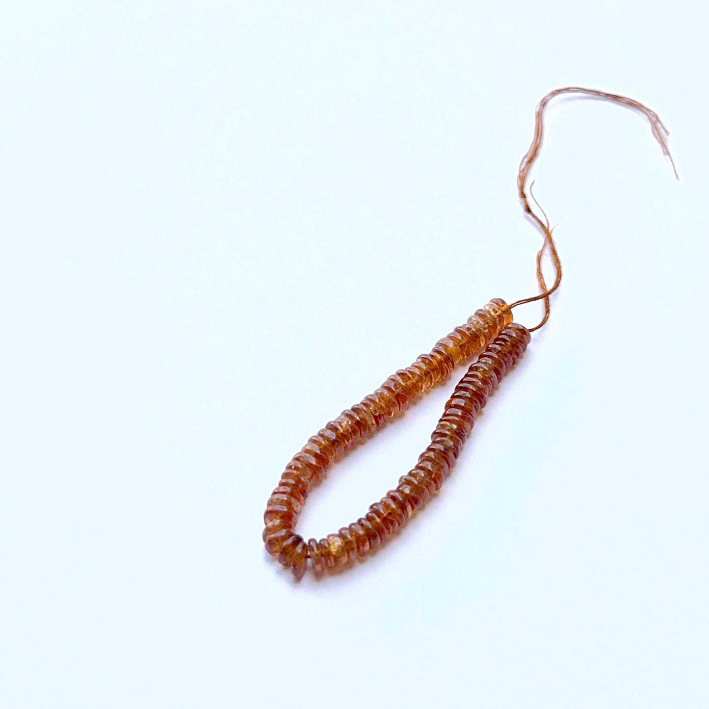 Hessonite 4.5–4.7mm smooth wheel beads arranged on a strand, showing clarity, shine and natural gemstone texture.
