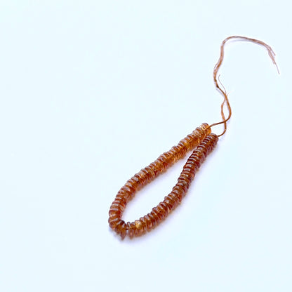 Hessonite 4.5–4.7mm smooth wheel beads arranged on a strand, showing clarity, shine and natural gemstone texture.