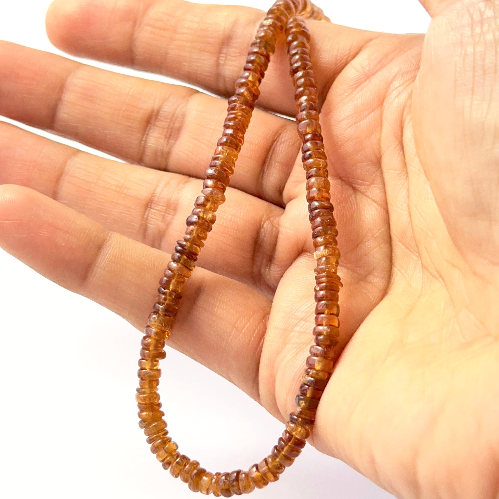 Hessonite smooth wheel beads aligned on a strand, highlighting colour, clarity and quality stone beads.