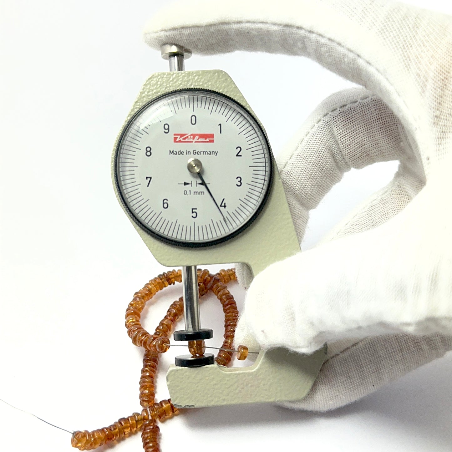 A dial gauge measures the Hessonite smooth wheel 4.3–4.6mm gemstone.