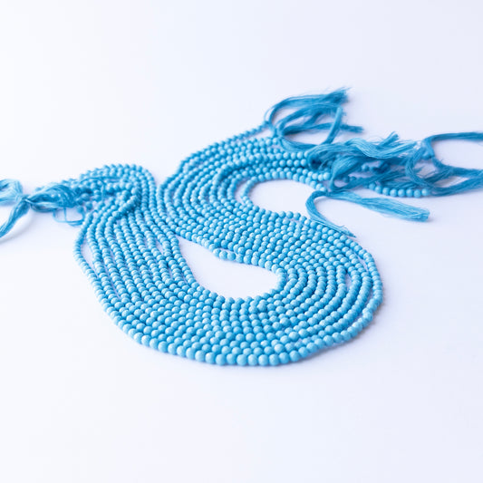 Howlite Turquoise faceted rondelle beads displayed in multiple strands, showing consistent 3.1mm sizing and natural veining.