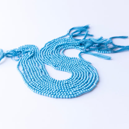 Genuine Howlite Turquoise gemstone beads in faceted rondelle cut, displaying polish, texture, and bold turquoise hues.