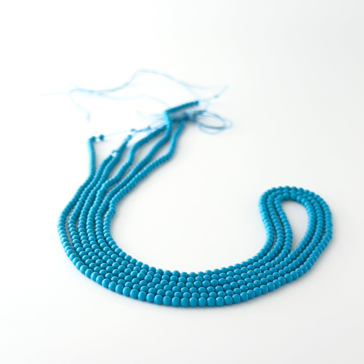 Smooth round Howlite Turquoise beads arranged neatly, highlighting their glossy surface and handmade jewellery component quality