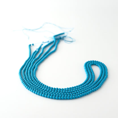 Smooth round Howlite Turquoise beads arranged neatly, highlighting their glossy surface and handmade jewellery component quality