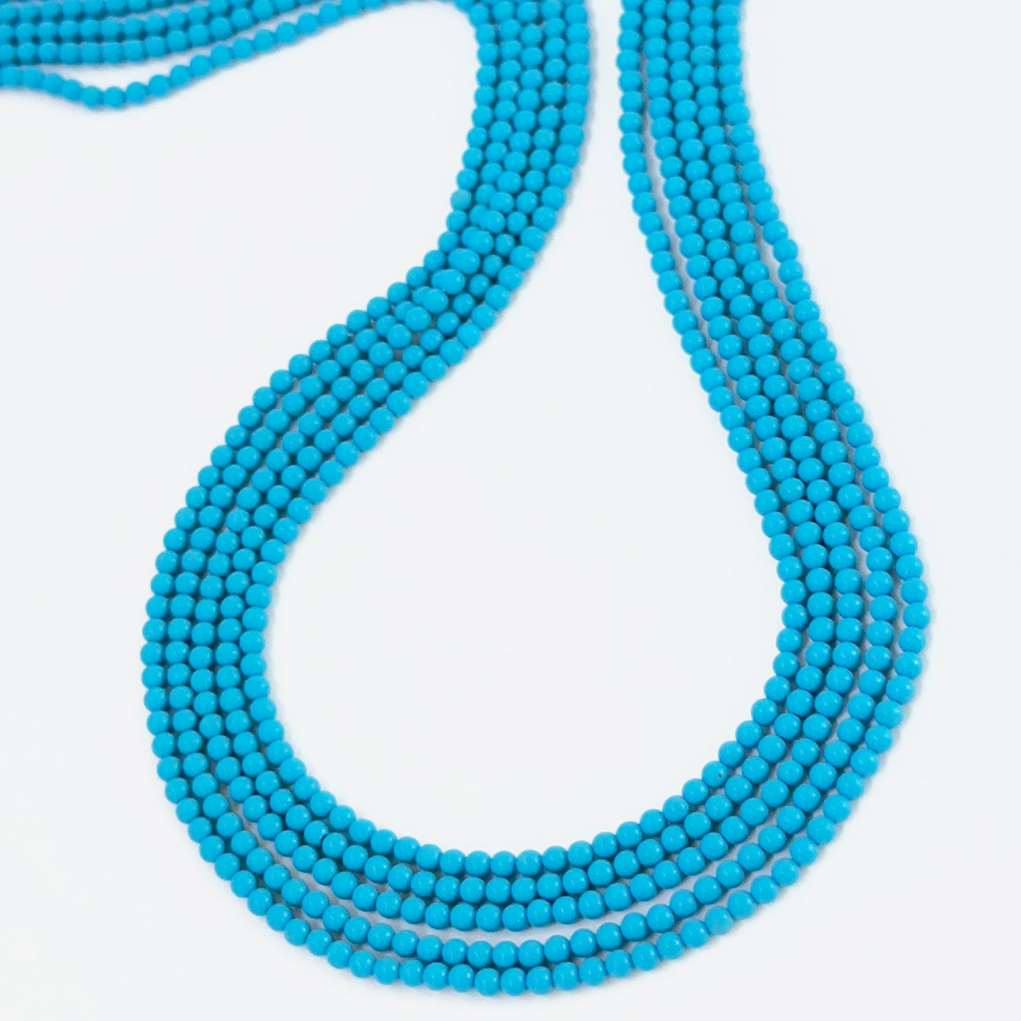 Natural Howlite Turquoise round beads showing soft blue tones and smooth polish.