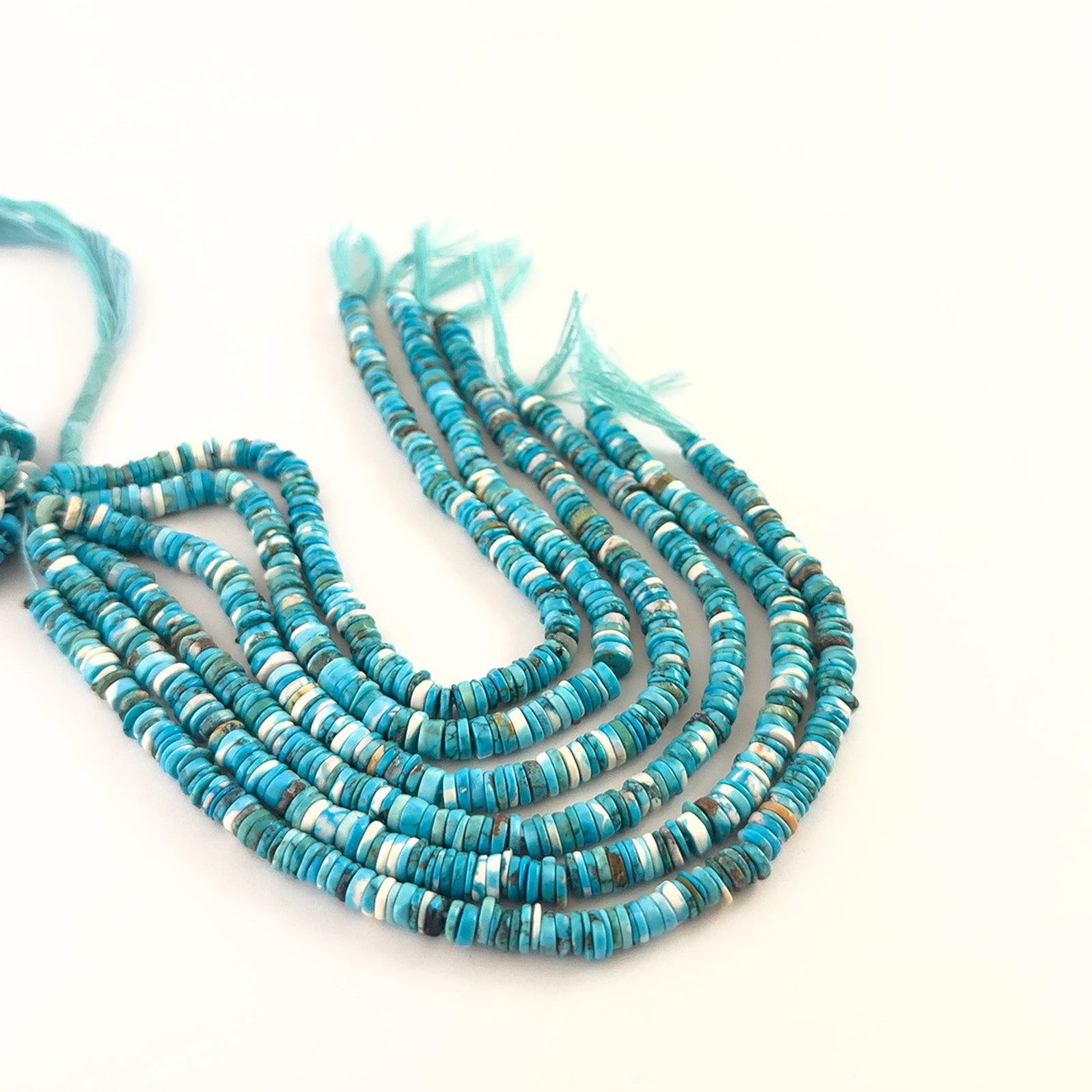 Close‑up of Howlite Turquoise smooth wheel heishi beads highlighting their rounded edges and bright blue tones.