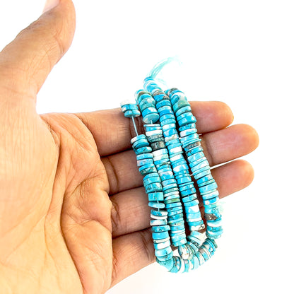 A person holds delicate strands of Howlite Turquoise beads, showcasing their smooth wheel heishi design.