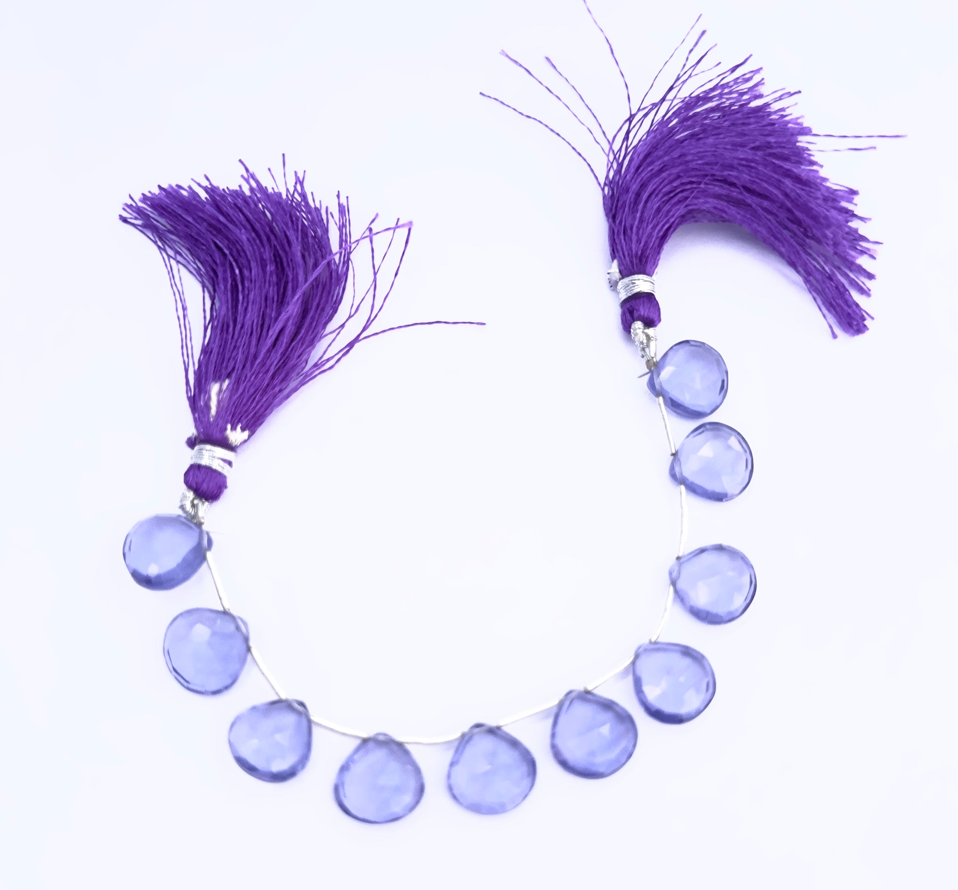 Close-up of Hydro heart briolette beads showing their clarity, cut, and vibrant colour.