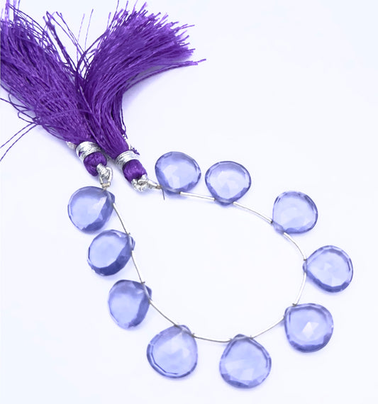 Hydro faceted heart briolette gemstone beads arranged in a circular strand with tassel accents.