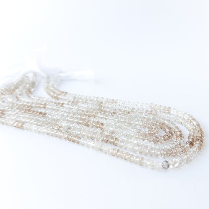 Handmade jewellery components featuring faceted Imperial White Topaz rondelle beads in a neatly arranged strand.