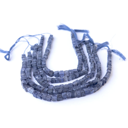 Authentic iolite gemstone beads showcasing deep violet‑blue tones and uniform cube cuts.