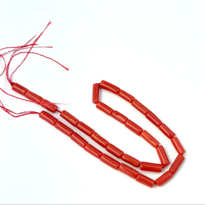 Italian Coral smooth cylinder beads in 3.5mm or 4mm size arranged neatly for DIY jewellery making.