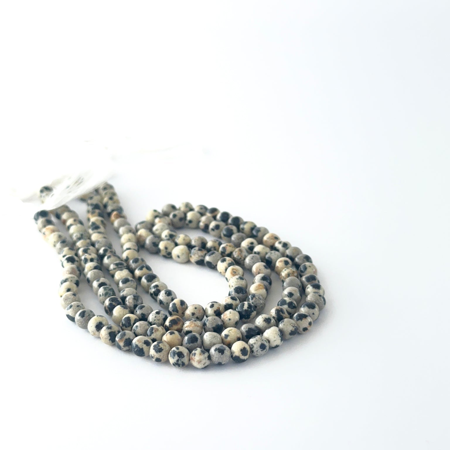 Smooth round Jasper beads arranged neatly, highlighting their glossy surface and handmade jewellery component quality.