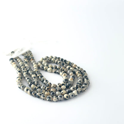 Smooth round Jasper beads arranged neatly, highlighting their glossy surface and handmade jewellery component quality.