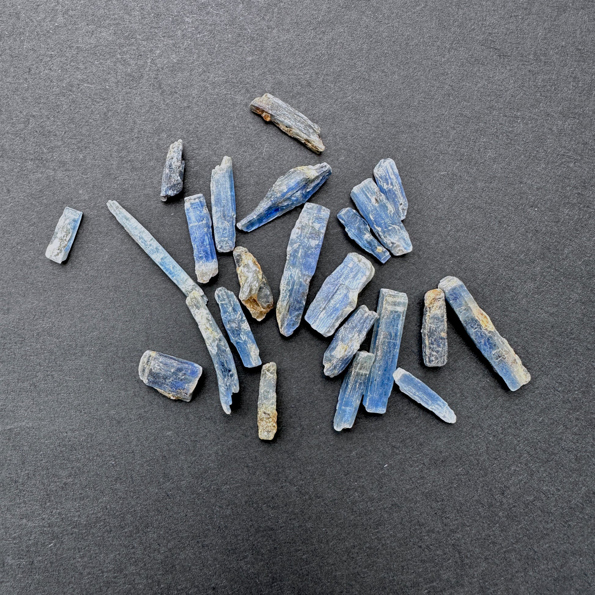 Kyanite gemstones laid flat to highlight their rough cut and elongated shape.