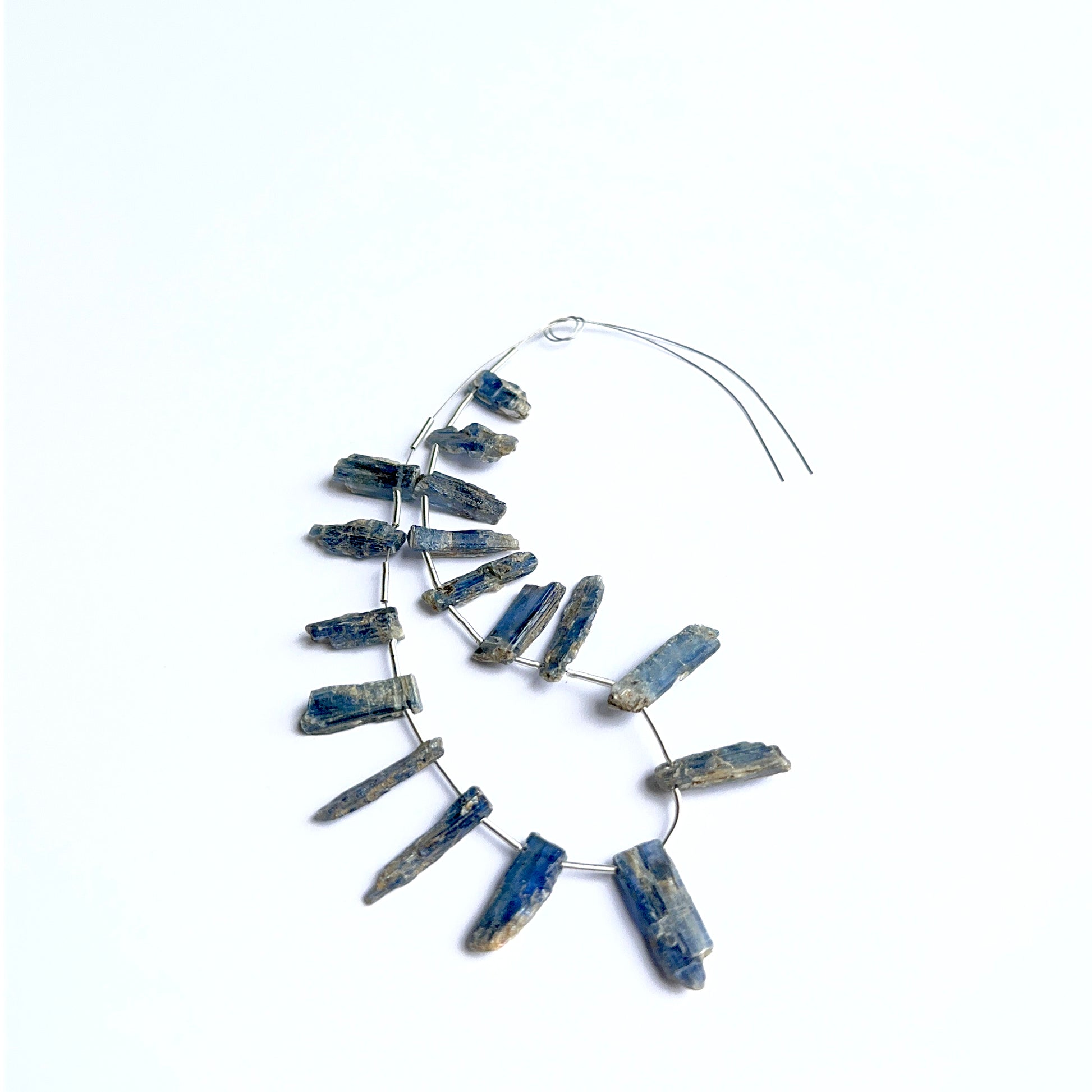 Kyanite rough stones photographed to show their unpolished finish and suitability for handmade jewellery components.