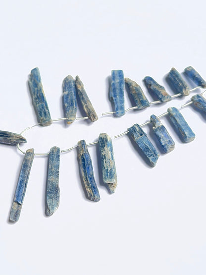 Raw kyanite stones displayed with visible striations ideal for natural gemstone beads in jewellery making.