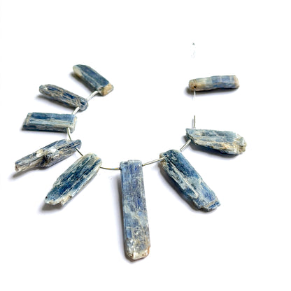 Kyanite rough stones photographed to show their unpolished finish and suitability for handmade jewellery components.