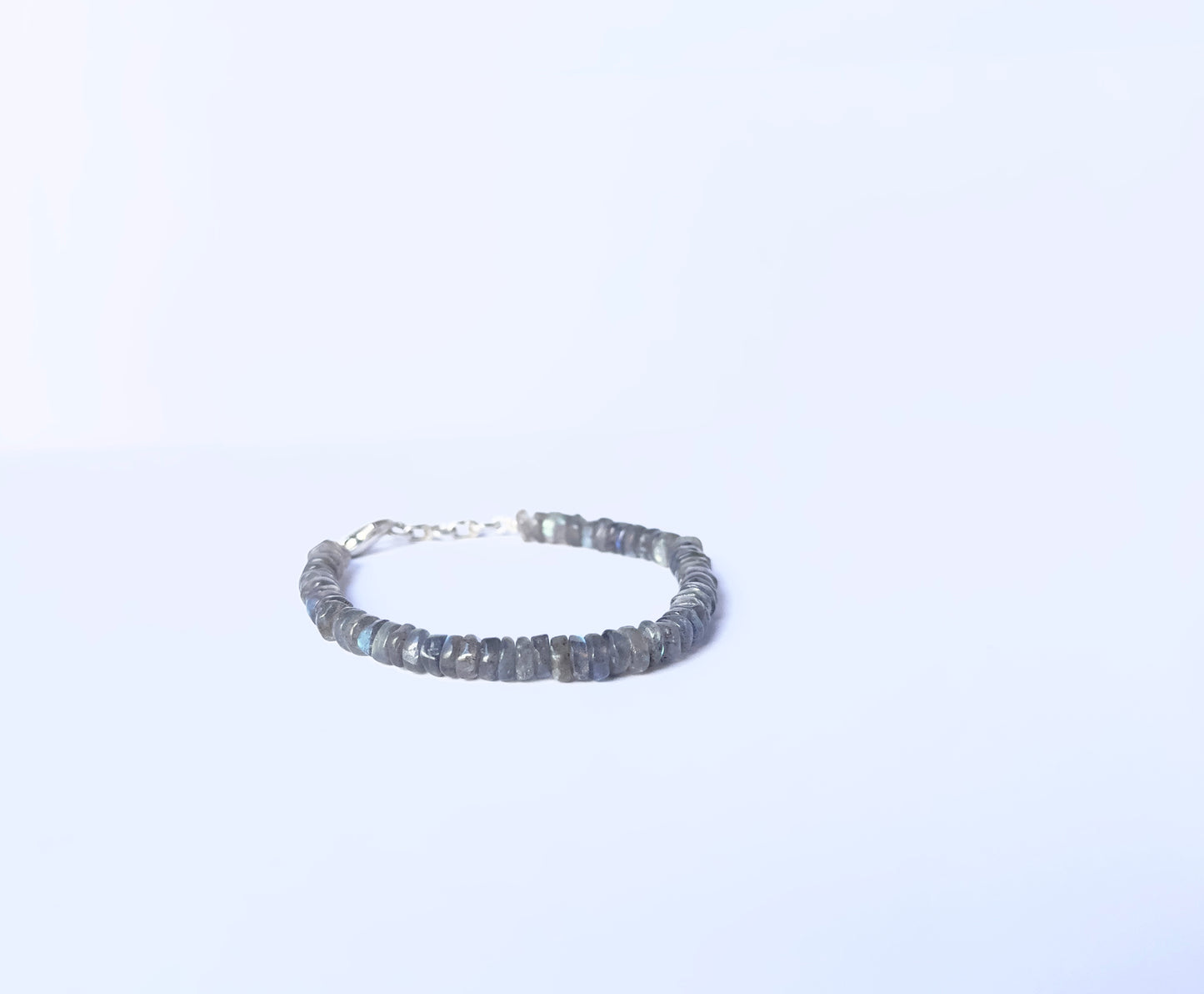 Close-up of natural gemstone beads in a Labradorite bracelet with polished finish.