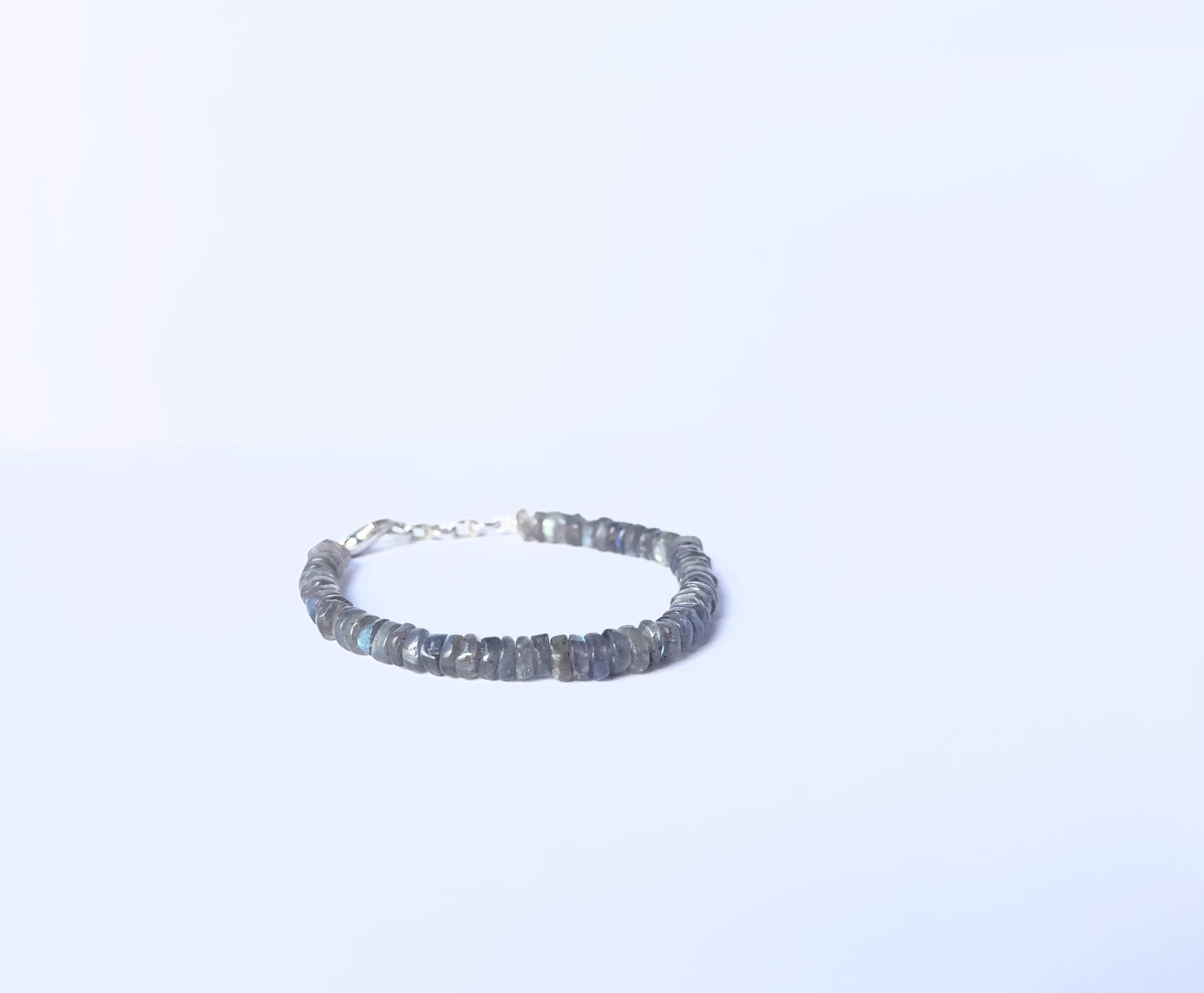 Close-up of natural gemstone beads in a Labradorite bracelet with polished finish.