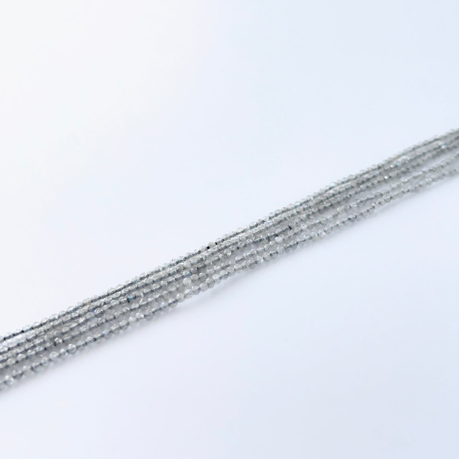 Labradorite faceted rondelle beads showing soft flashes of blue and green.