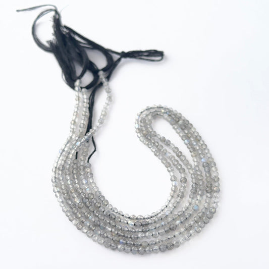 Labradorite faceted rondelle beads showing soft flashes of blue and green.