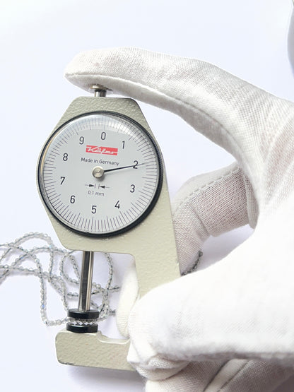 A dial gauge measures the Green Opal faceted rondelle 3.8–4mm gemstone.