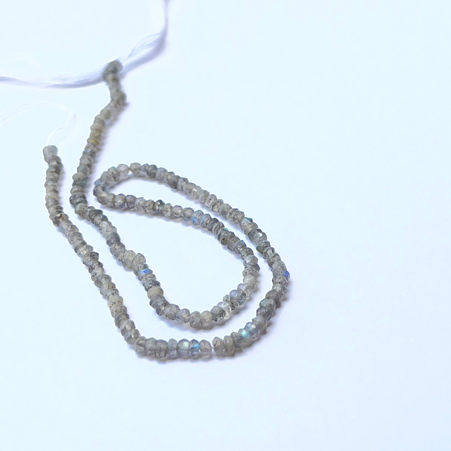 Close‑up of Labradorite stone beads in faceted rondelle cut, highlighting shimmer and precision for handmade jewellery components.