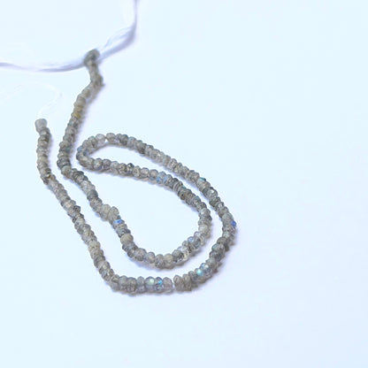 Close‑up of Labradorite stone beads in faceted rondelle cut, highlighting shimmer and precision for handmade jewellery components.