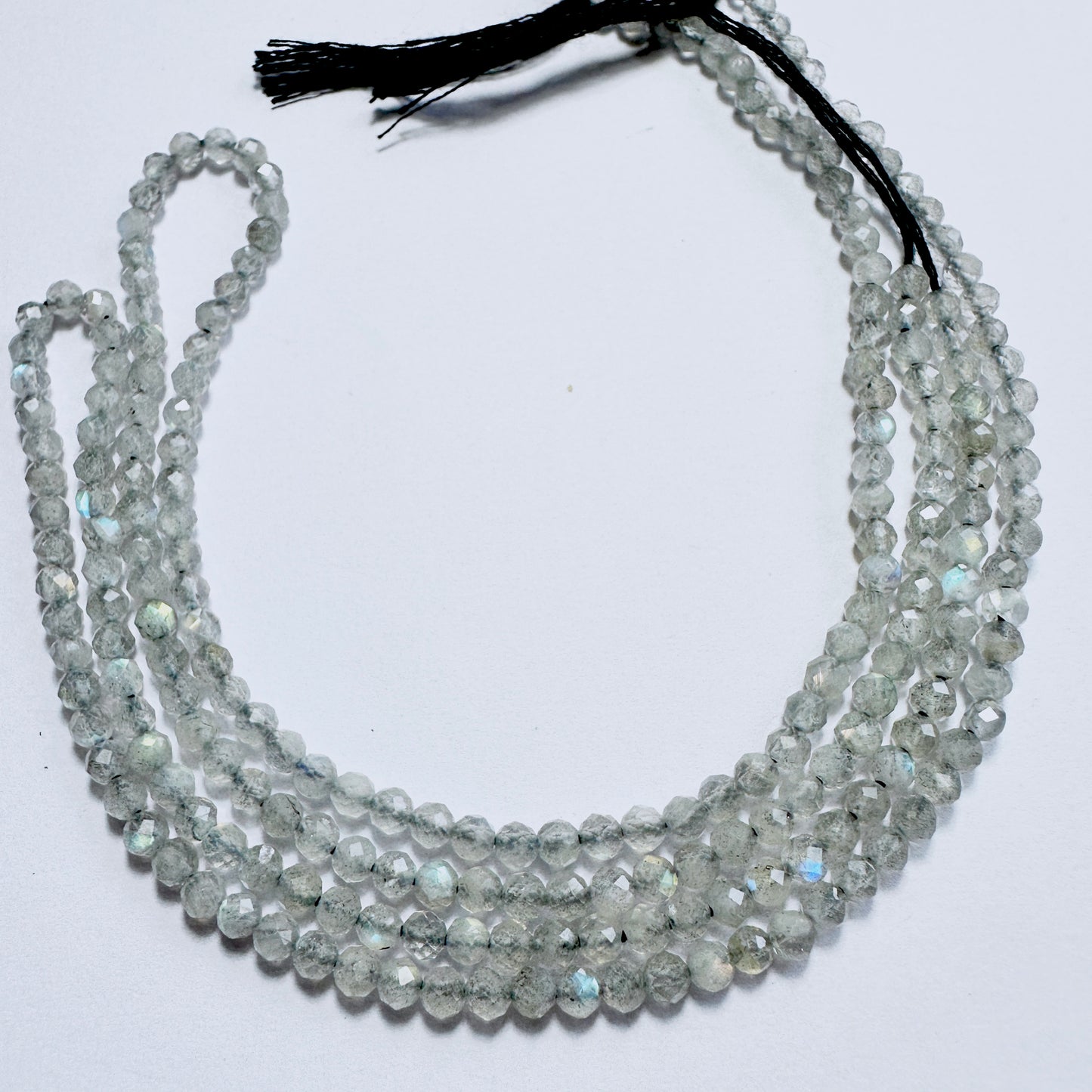 Close-up of Labradorite stone beads with faceted rondelle cut, showcasing blue and green flashes for handmade jewellery components.
