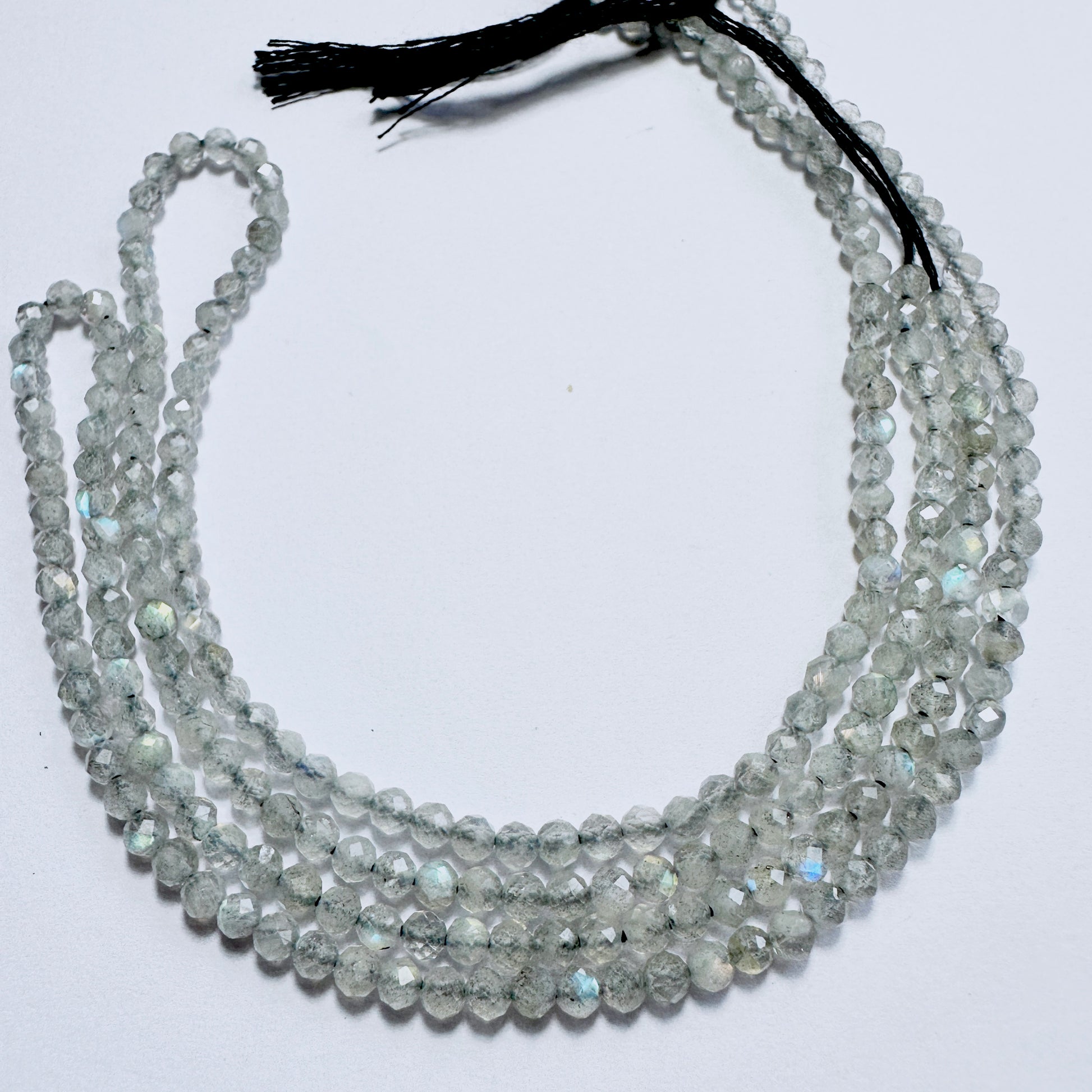 Close-up of Labradorite stone beads with faceted rondelle cut, showcasing blue and green flashes for handmade jewellery components.