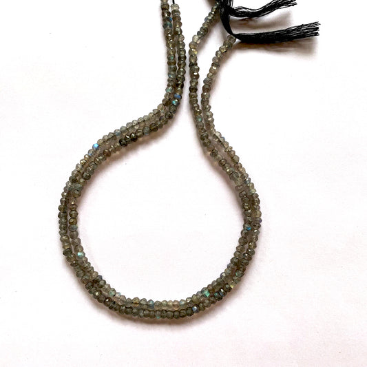 Natural Labradorite gemstones in faceted rondelle cut, capturing light with iridescent brilliance.