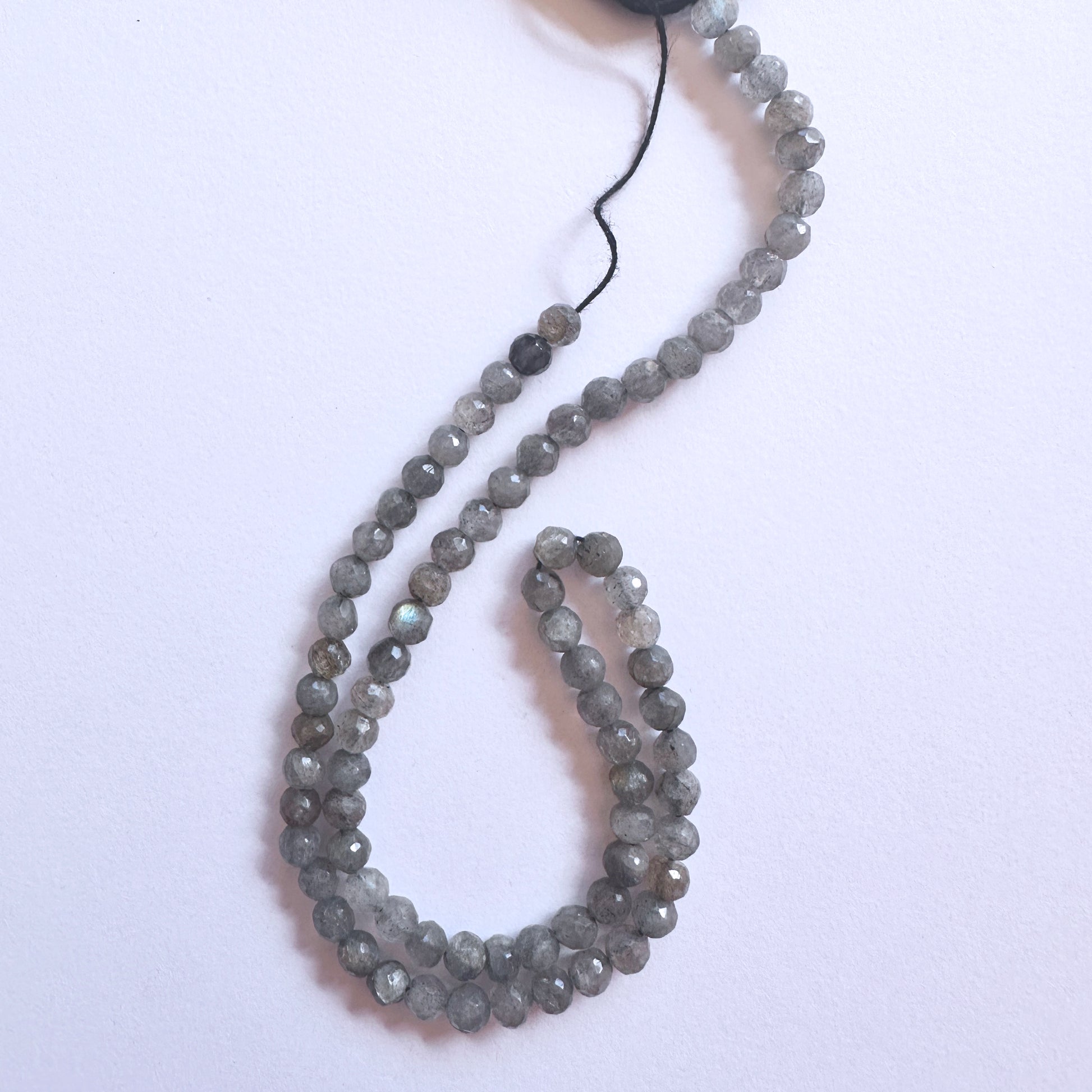 Close-up of Labradorite beads showcasing their luminous flashes and precision cut.