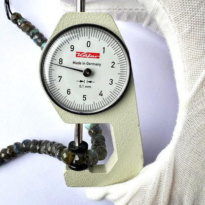 A dial gauge measures the Labradorite rondelle 8.2mm gemstone