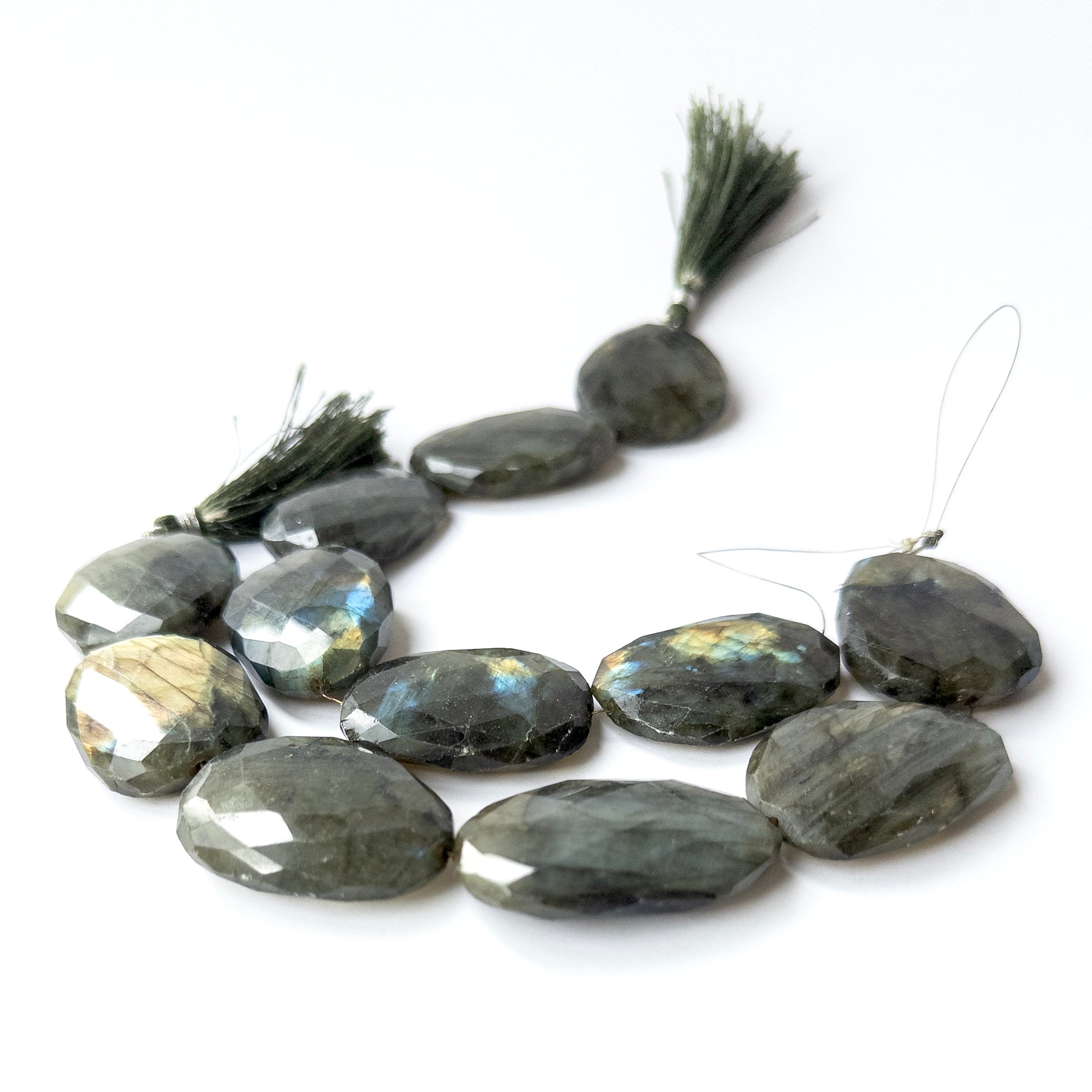 Close‑up of genuine Labradorite faceted oval stone beads with shimmering labradorescence and crisp cutting.