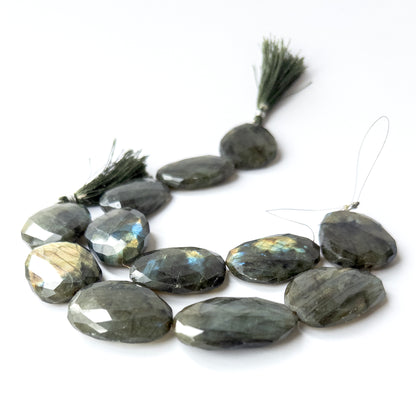 Close‑up of genuine Labradorite faceted oval stone beads with shimmering labradorescence and crisp cutting.