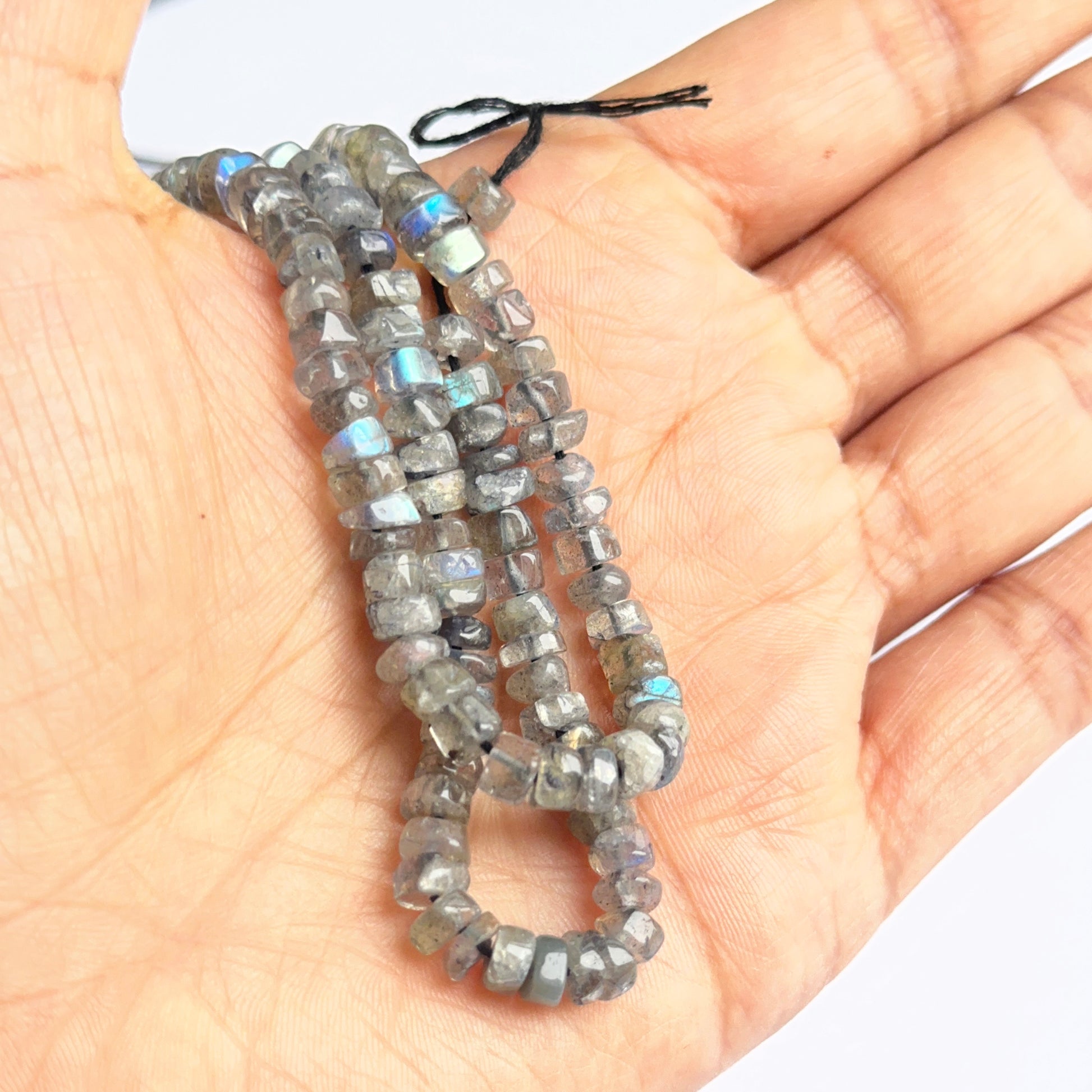 Labradorite smooth wheel heishi beads photographed to show clarity, labradorescence and natural beauty.