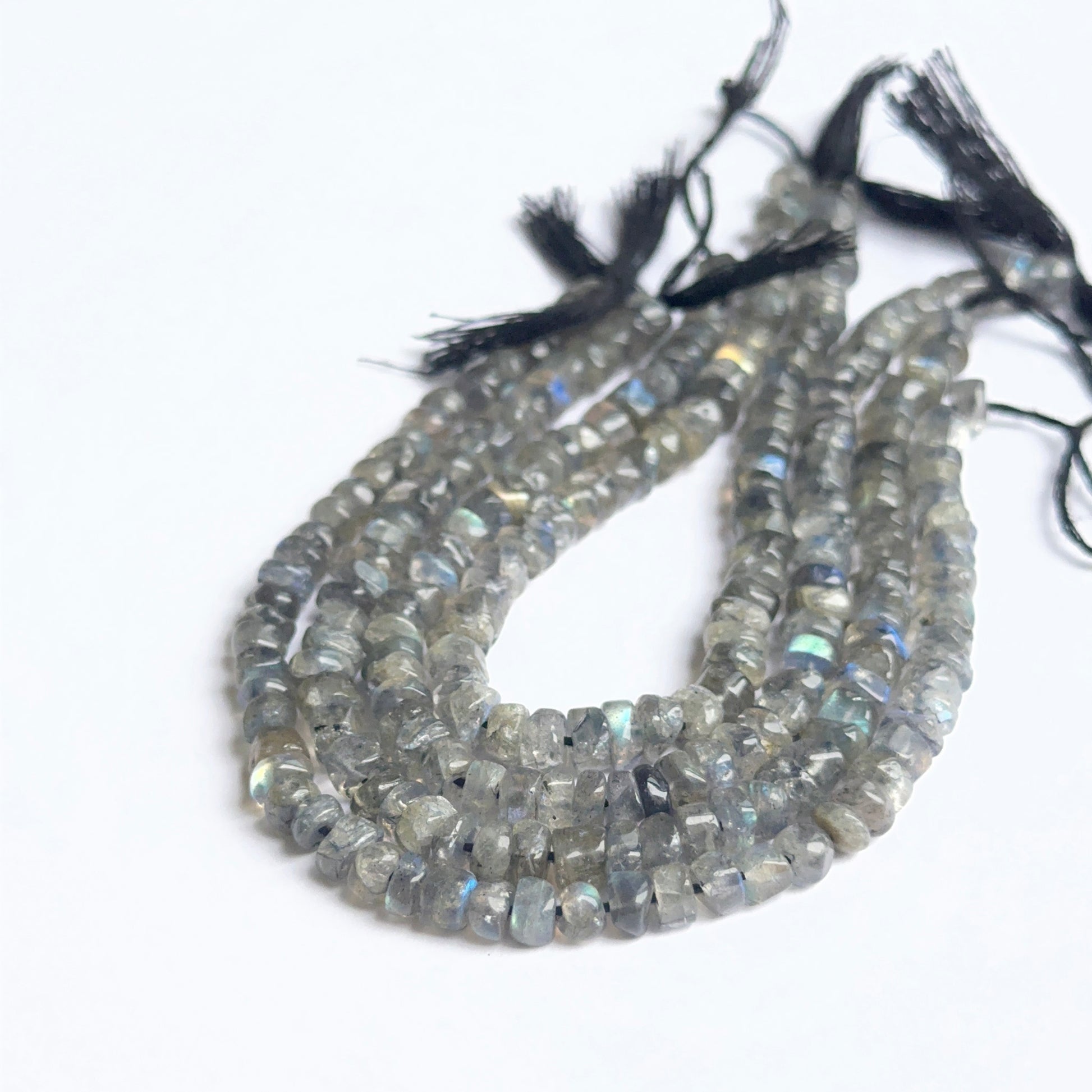 Smooth wheel labradorite beads displayed with clean surfaces ideal for gemstone jewellery making.